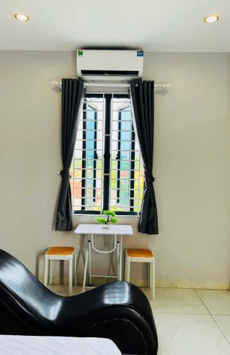 a black leather chair sitting in front of a window at Nhà Nghỉ Sukha in Ba Vì