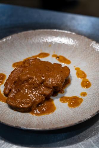 a plate with a piece of food with sauce on it at Hotel HDomus in Nogarole Rocca