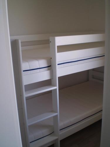 a white bunk bed with white shelves in a room at Ferienwohnung Marinablick in Wendtorf