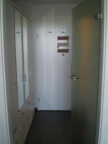 a hallway with a white door and some books at Ferienwohnung Marinablick in Wendtorf
