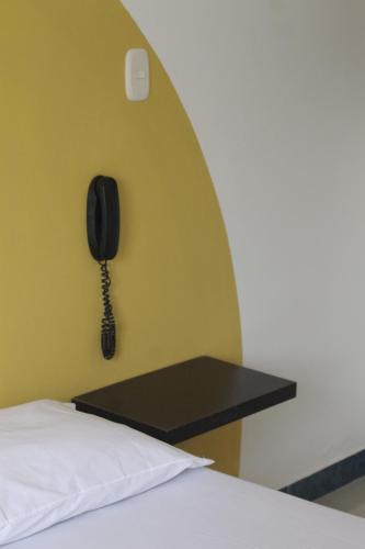 a phone hanging on a wall next to a bed at Hotel Cielo de Tambores in Cali