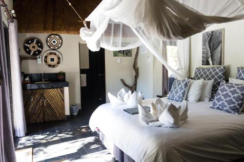 a bedroom with a bed with white pillows at Ezulwini Game Lodges in Balule Game Reserve