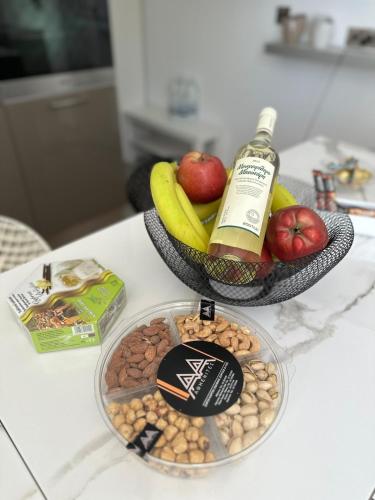 a bowl of nuts and a bottle of wine and a bowl of fruit at Modern house in Larnaca in Larnaka