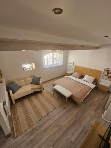 a bedroom with a large bed and a couch at Mediterranean Studio in Saint-Cyprien