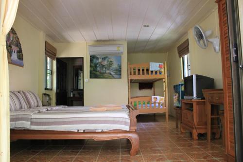 a bedroom with a bed and a tv in it at Buffalo Bay Vacation Club in Ko Phayam
