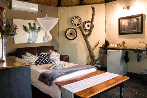 a bedroom with a bed and a table in it at Ezulwini Game Lodges in Balule Game Reserve