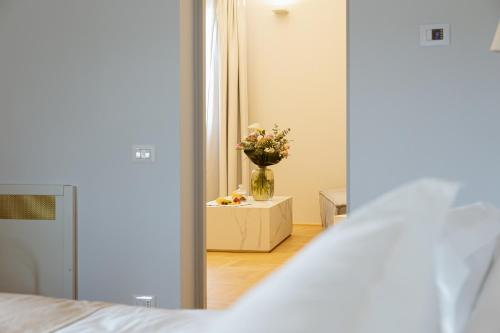 a bedroom with a vase of flowers on a table at Palazzo Zimara Boutique Hotel in Lecce