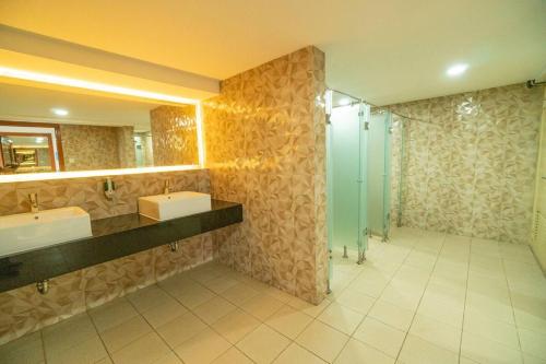 a bathroom with two sinks and a glass shower at 1 BR Comfy & Premium Entire Apt By Deeta Living in Jakarta