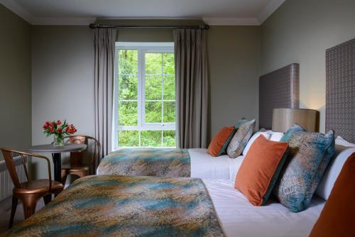 um quarto de hotel com duas camas e uma janela em The Reserve at Muckross Park em Killarney