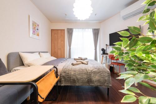 a bedroom with a bed and a couch at Oasis Stay Tokyo in Soka