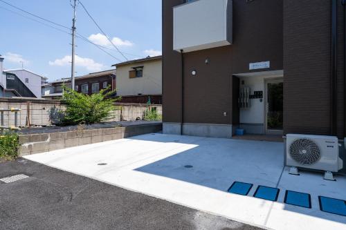 a building with a fan sitting outside of it at Oasis Stay Tokyo in Soka