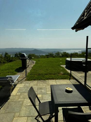 Un patio con una mesa y sillas y una sombrilla. en relaxing lake view, en Nebbiuno