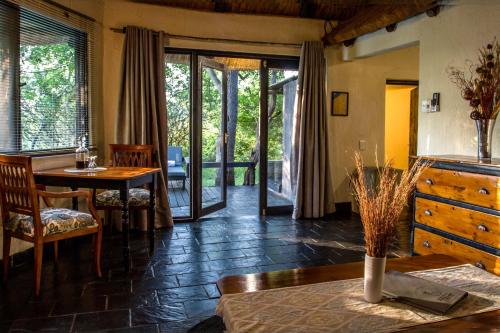 a living room with a table and a dining room at Ezulwini Game Lodges in Balule Game Reserve