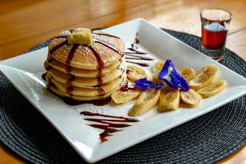 a white plate with a stack of pancakes and chips at Bamboo Surf Beach in San Isidro