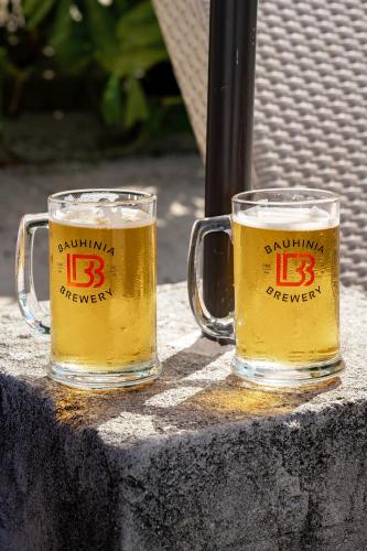 two glasses of beer sitting on a table at Bamboo Surf Beach in San Isidro