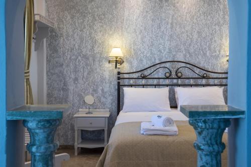 a bedroom with a bed and two blue tables at Contaratos Beach Hotel in Naousa