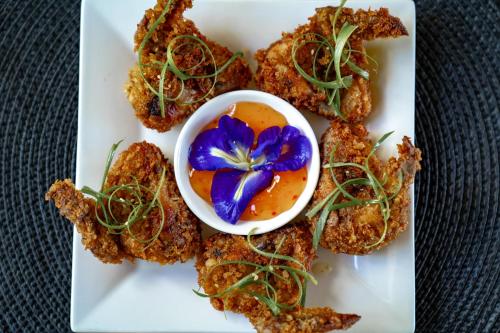 a plate of fried food with a blue flower on it at Bamboo Surf Beach in San Isidro
