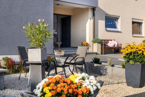 a patio with a table and chairs and flowers at Hotel Garni Sonnengruss in Hagnau