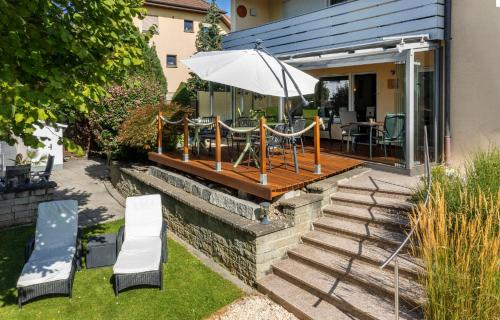 a patio with an umbrella and a table and chairs at Hotel Garni Sonnengruss in Hagnau