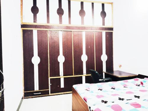 a bedroom with a bed and a table and a fence at Ramashish kutir hotel in Banāras Cantonment