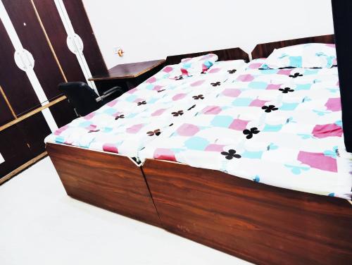 a bed with a wooden frame in a room at Ramashish kutir hotel in Banāras Cantonment