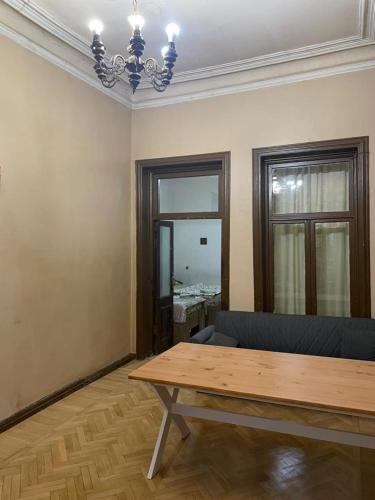 a living room with a wooden table and a chandelier at City center house in Kutaisi