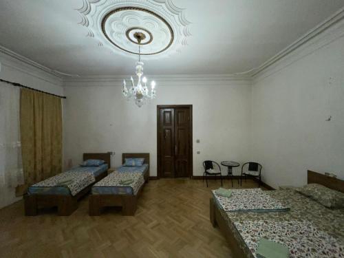 a room with two beds and a chandelier at City center house in Kutaisi
