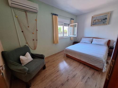 Un dormitorio con una cama y una silla dentro. en Apartman Mari, en Trogir