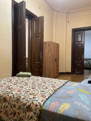 a bedroom with a large bed with a colorful blanket at Central House in Kutaisi