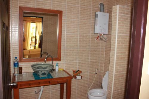 a bathroom with a sink and a toilet and a mirror at Buffalo Bay Vacation Club in Ko Phayam