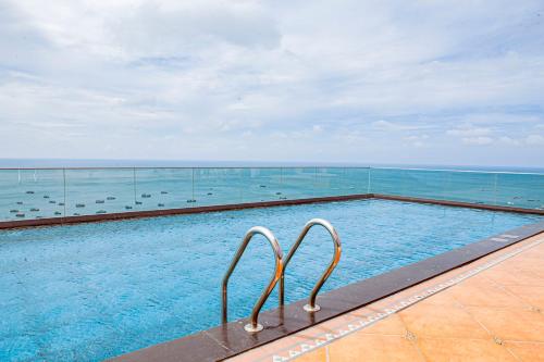 a swimming pool with a view of the ocean at Sunset Town Apartments Free Gym & Pool in Phu Quoc