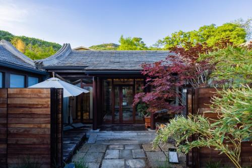 a house with a patio with an umbrella at 北京一瓢客栈 Beijing YiPiao Inn in Beijing