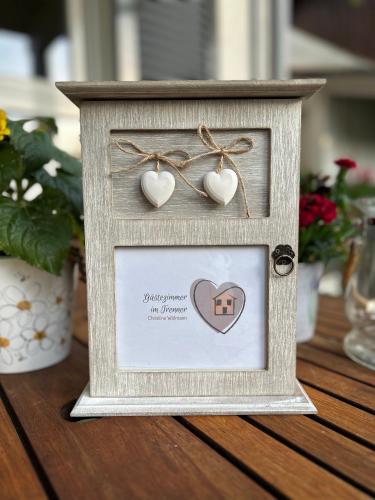 a frame with hearts and a picture of a house at Gästezimmer im Trenner in Taufkirchen