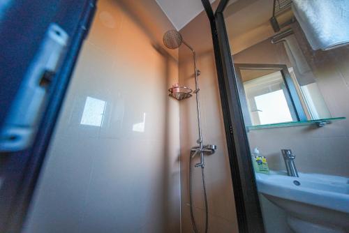 a bathroom with a shower and a door with a mirror at Allee coco in Trou aux Biches