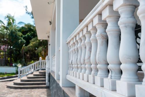 a white balcony of a building with stairs at Allee coco in Trou aux Biches