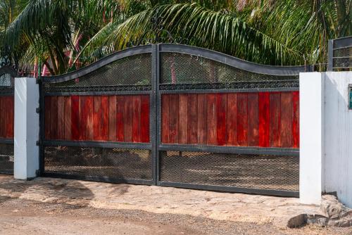 a black and red gate with a fence at Allee coco in Trou aux Biches