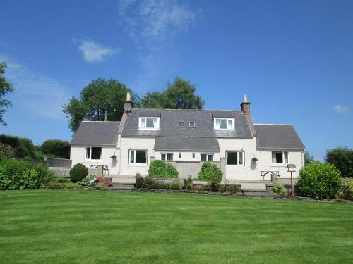 a large white house with a large yard at Eastwood Cottage in Turriff
