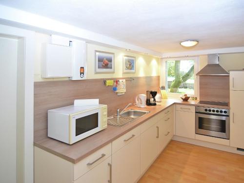 a kitchen with a microwave and a sink at Ferienwohnung in Löwensen mit eigener Terrasse in Bad Pyrmont