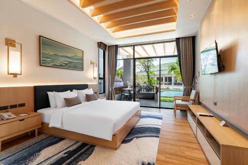 ein Hotelzimmer mit großem Bett und Balkon in der Unterkunft AZ Sunrise Resort & Fitness Club in Layan Beach