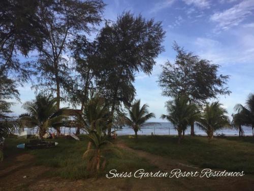a group of palm trees on the beach at Pool & Sea View Casa Azalea at Swiss Garden Resort Residence - 2 bedroom apartment in Kuantan