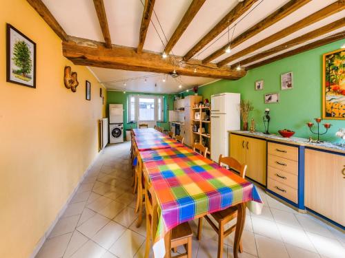 a colorful kitchen with a long table with chairs at Forestside Escape for 15 Guests in Awenne