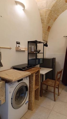 a laundry room with a washing machine and a table at B&B VIA NAPOLI LEVERANO in Leverano
