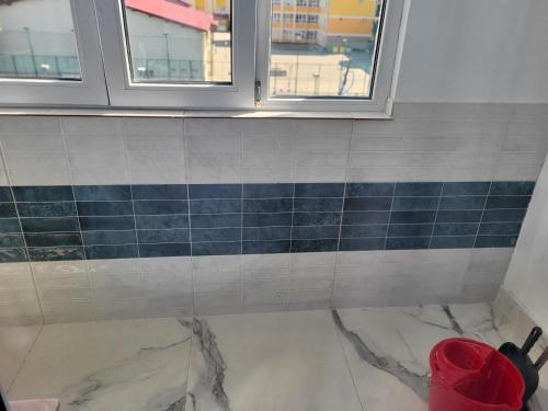 Un baño con azulejos azules y grises en la pared. en Apartament Cristi, en Bistriţa