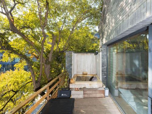 a bedroom with a tree on the side of a building at 北京一瓢客栈 Beijing YiPiao Inn in Beijing