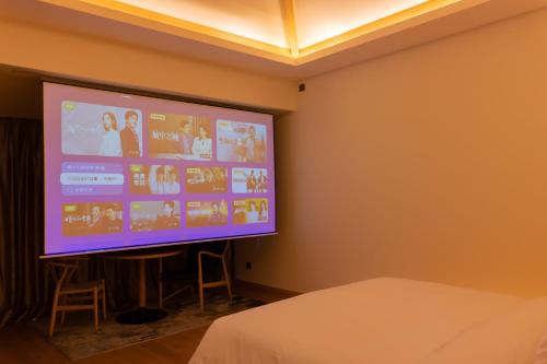 a projection screen in a room with a bed at 北京一瓢客栈 Beijing YiPiao Inn in Beijing