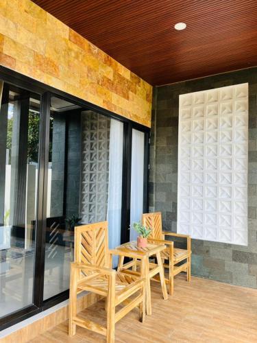 a patio with two chairs and a table on a porch at The Res Village Lombok in Kuta Lombok