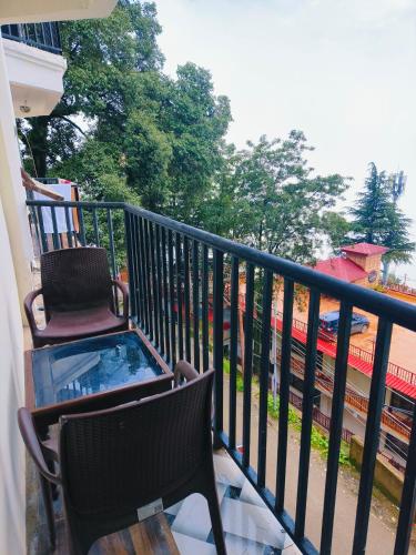 a balcony with two chairs and a hot tub on it at HOTEL HOLIDAY PLAZA DALHOUSIE - Near Ghandhi Chowk Mall Road in Dalhousie