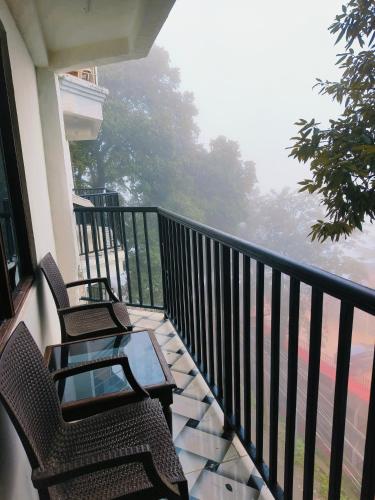 two chairs and a table on a balcony at HOTEL HOLIDAY PLAZA DALHOUSIE - Near Ghandhi Chowk Mall Road in Dalhousie