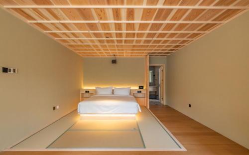 a bedroom with a bed and a wooden ceiling at 北京一瓢客栈 Beijing YiPiao Inn in Beijing