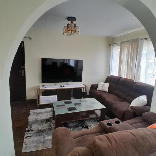 a living room with a couch and a table at Evin apartment in Gilgil